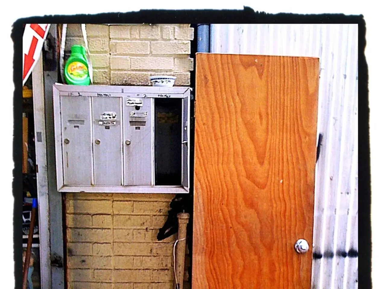 In the picture we can see a photograph of a wall with a wooden door and beside it, we can see a...