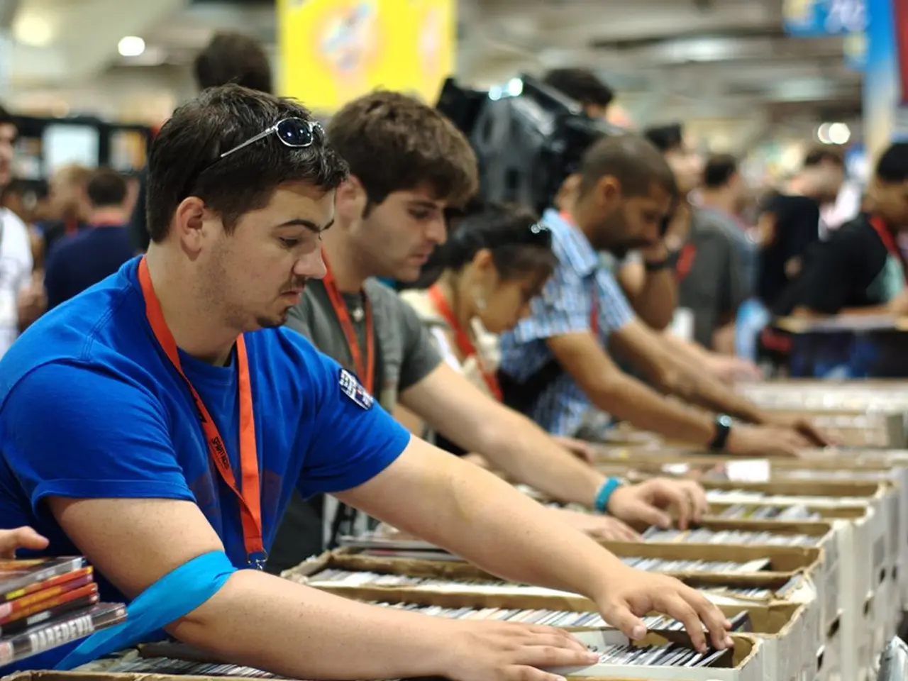 In this image there are group of people who are setting the books in the boxes with their hands....