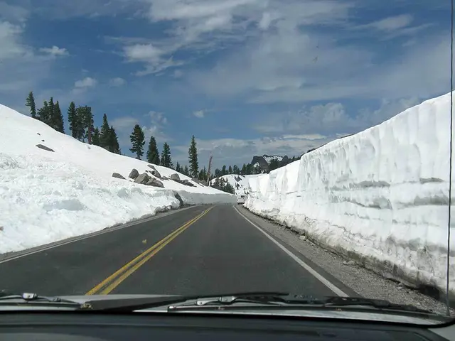 This picture has been captured from the vehicle, from which we can see there empty road and snow...