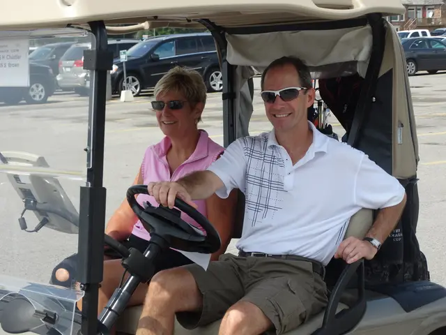 In this image we can see a woman and a man sitting in a vehicle containing some golf sticks in a...