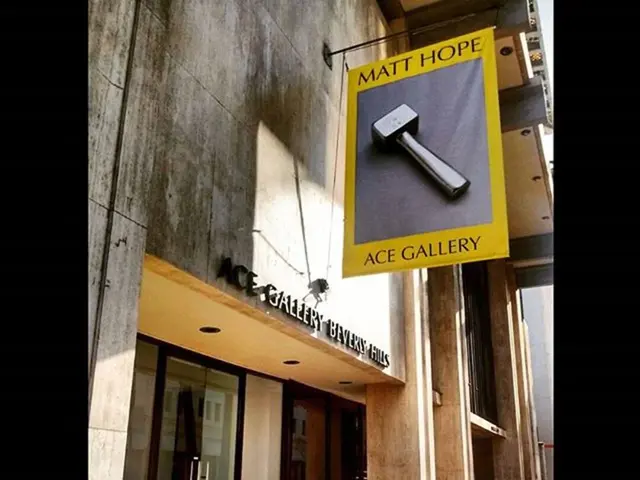 In this picture we can see a store. This is a wall. We can see a banner hanged to a stand. This is...