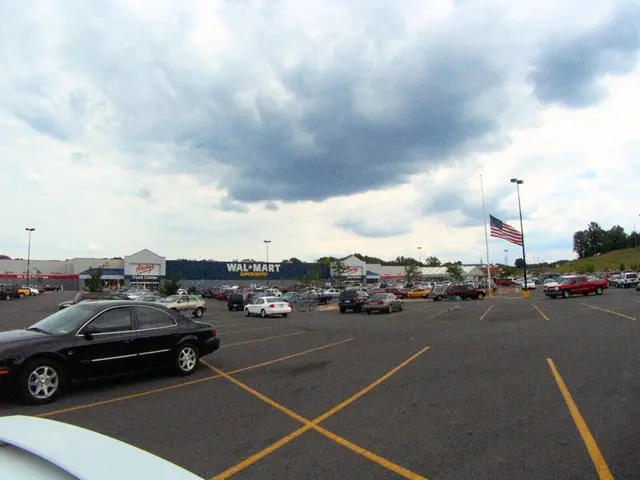 In this image we can see a parking area. There are many vehicles. Also there are poles. And there...