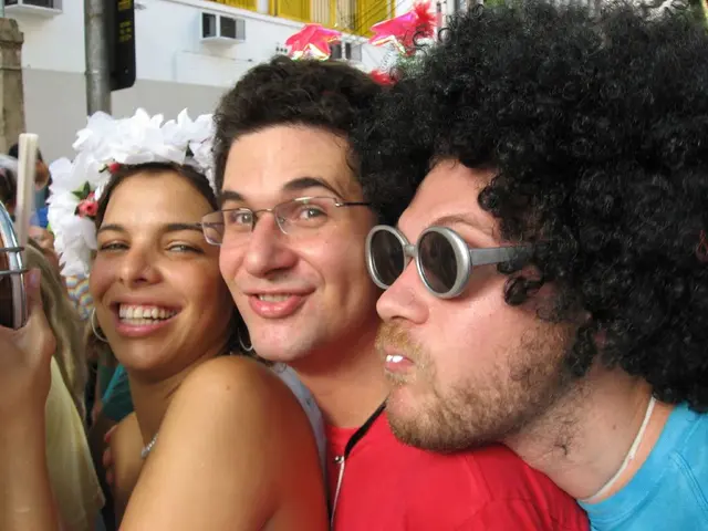 This image consists of three persons. On the right, the man is wearing a blue T-shirt. In the...