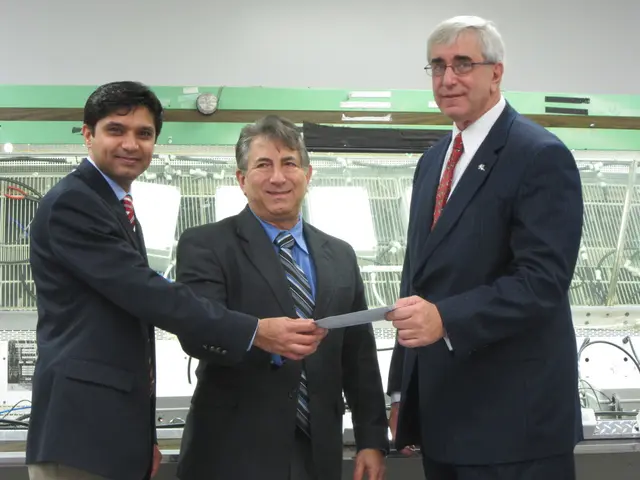 In this picture there are men those who are standing in the center of the image, by holding a paper...