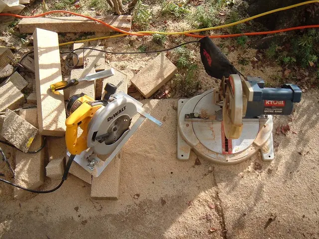 In the center of the image we can see wood cutter machines, wooden sticks, wires are there. At the...